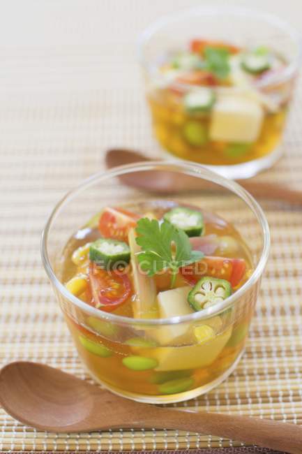 Closeup view of vegetable jelly in glasses with wooden spoons — Stock Photo
