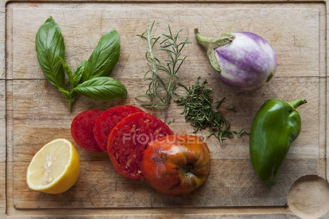 Legumes frescos, ervas e meio limão em uma tábua de cortar — Fotografia de Stock