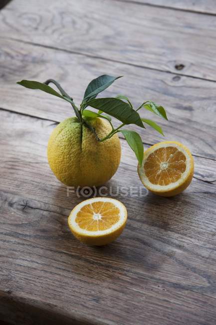 Апельсины с половинками и листьями — стоковое фото