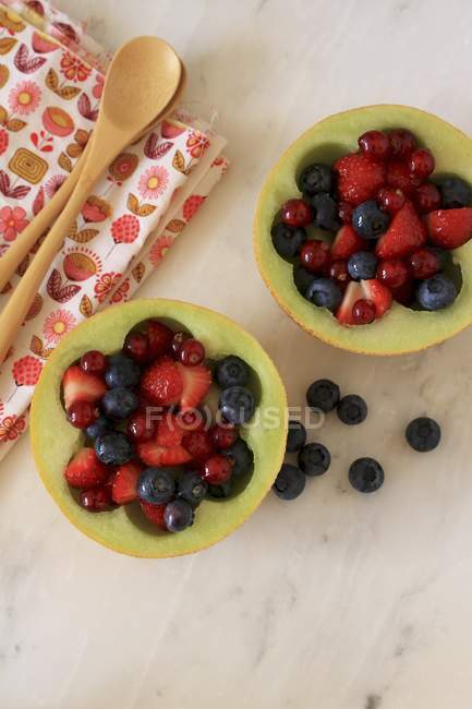 Mescolanza di bacche in metà di melone — Foto stock