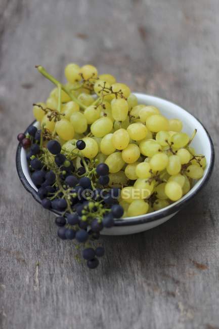 Виноград в емальованій мисці — стокове фото