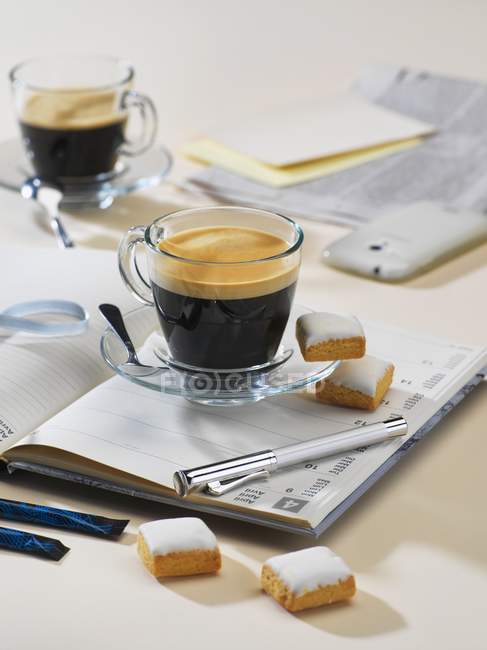 Kaffee und Kuchen auf dem Notizbuch — Stockfoto