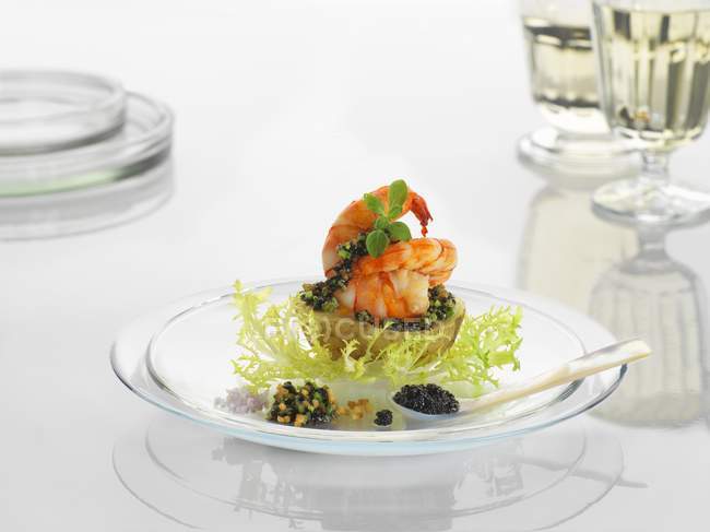 A new potato with prawns and caviar on a glass plate — Stock Photo