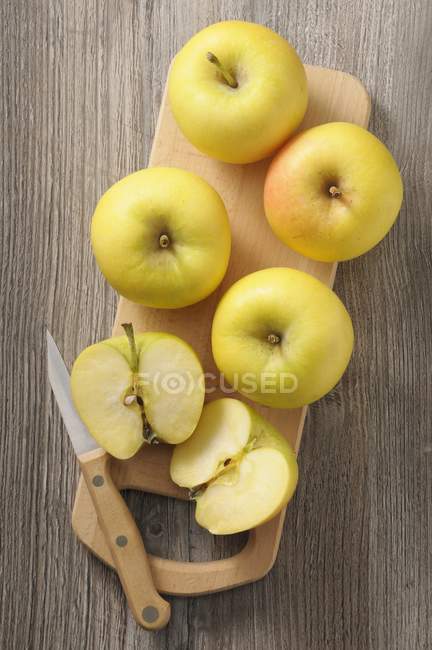 Желтые яблоки на столе — стоковое фото