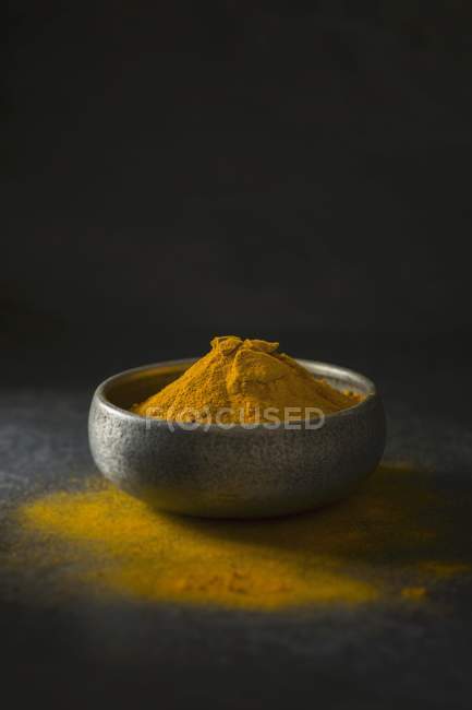 Ground turmeric in metal bowl — Stock Photo