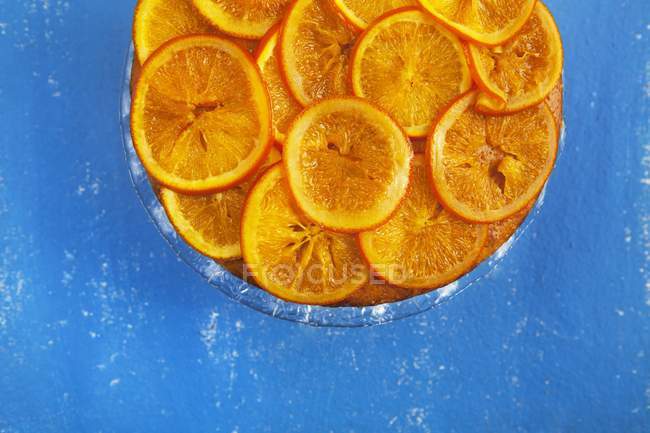 Оранжевый торт на голубой поверхности — стоковое фото