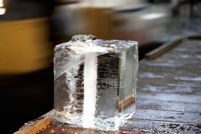 Vue rapprochée d'un grand bloc de glace sur une table en bois — Photo de stock