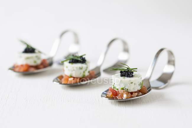 Tomatoes on canap spoons — Stock Photo