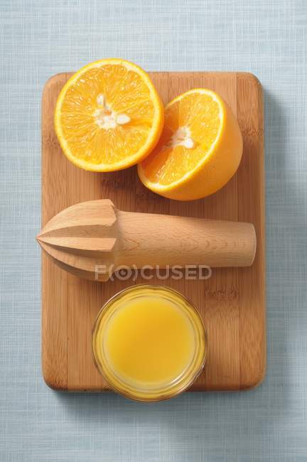Halved orange on wooden desk — Stock Photo