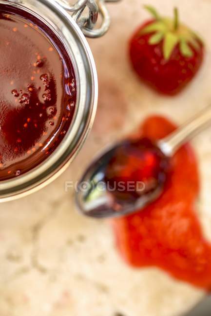 Mermelada de fresa en frasco y en cuchara - foto de stock
