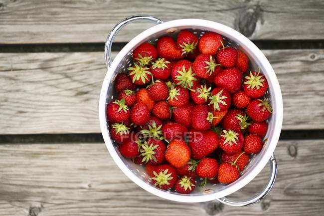 Fresh strawberries in colander — Stock Photo