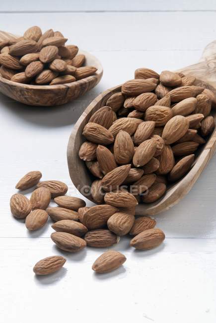 Almonds on scoops on white — Stock Photo
