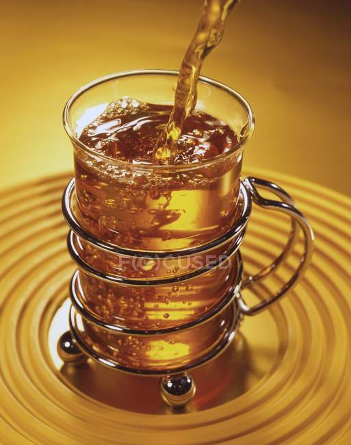 Nahaufnahme, wie man Tee in ein Teeglas gießt — Stockfoto