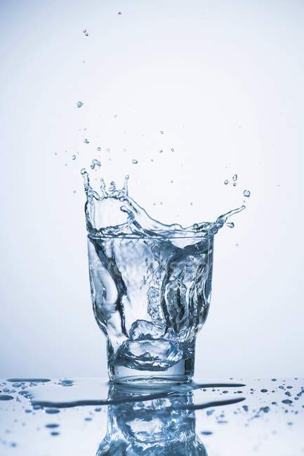 Wasser spritzt in ein Glas — Stockfoto
