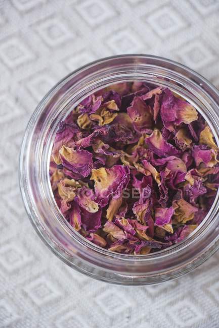 Closeup top view of dried rose petals in glass jar — Stock Photo