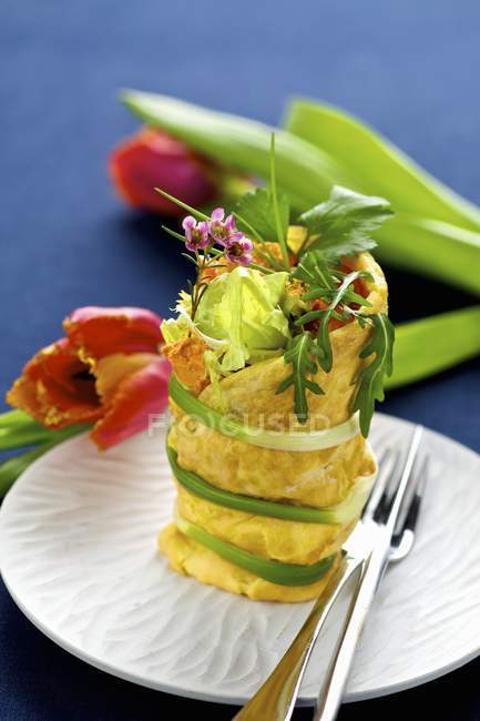 Stuffed omelette roll on white plate with forks — Stock Photo