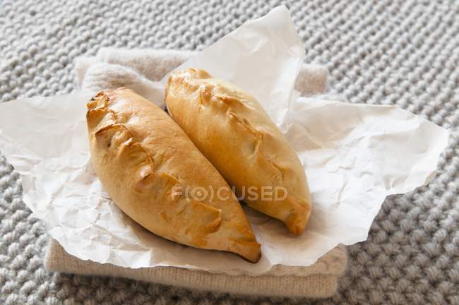 Meat pasties laying on paper — Stock Photo