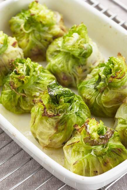 Stuffed, gratinated cabbage parcels  on white plate — Stock Photo