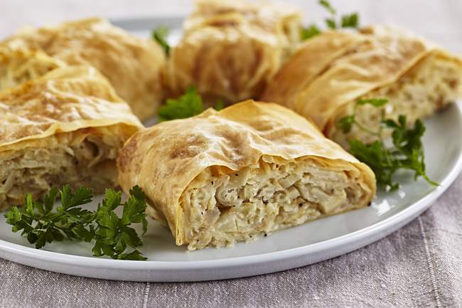 Cabbage strudel  on white plate over wooden surface — Stock Photo
