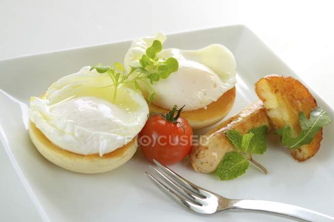 Huevos escalfados con salchicha y tomate - foto de stock