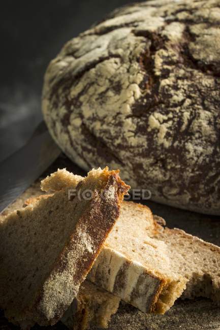 Slices of bread with loaf — Stock Photo