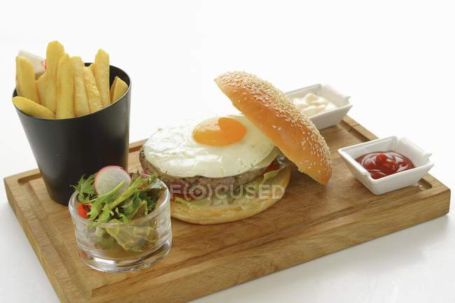 Hamburger con uovo fritto e patatine fritte — Foto stock
