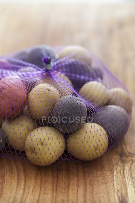 Net of various new potatoes — Stock Photo