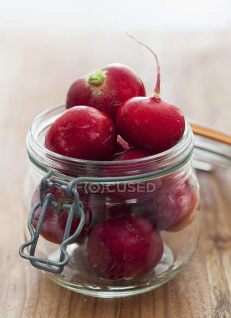 Fresh radishes in flip-top jar — Stock Photo