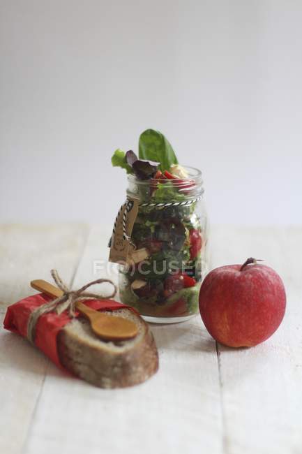 Ensalada en un frasco y manzana - foto de stock