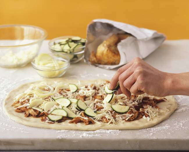Pizza being topped — Stock Photo