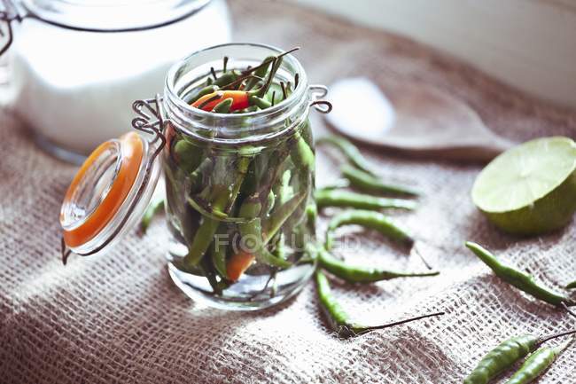 Closeup view of pickled chillies in a flip-top jar — Stock Photo