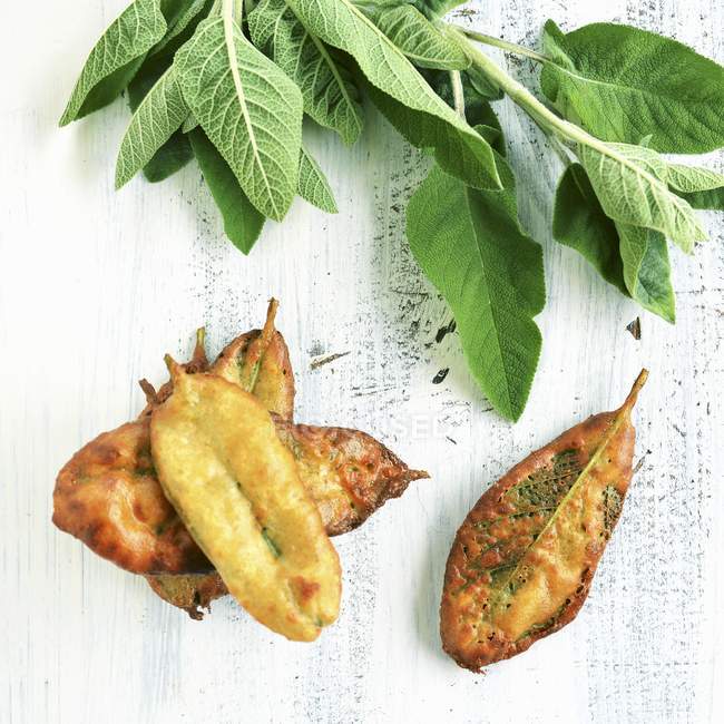 Closeup top view of deep-fried and fresh sage leaves — Stock Photo