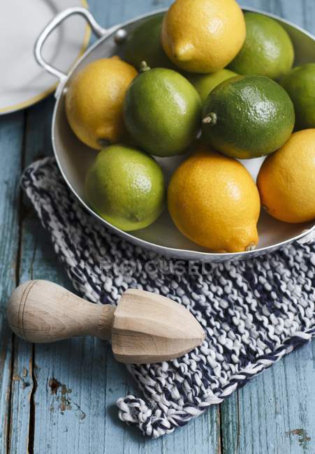 Limones frescos y limas en un tazón - foto de stock