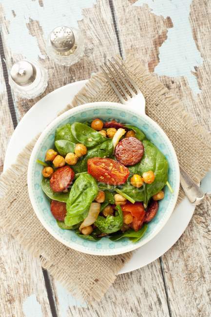 Spinach salad with roasted chickpeas and chorizo — Stock Photo