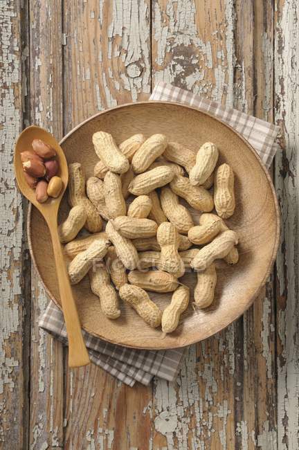Peanuts on wooden plate — Stock Photo
