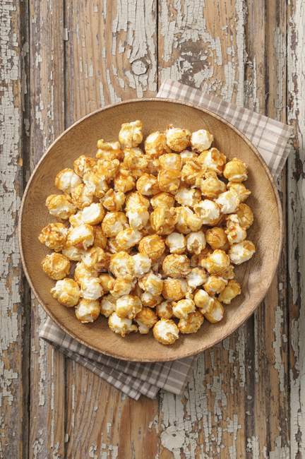 Popcorn on wooden plate — Stock Photo