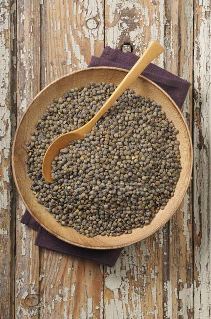 Top view of lentils with a wooden spoon on a plate — Stock Photo
