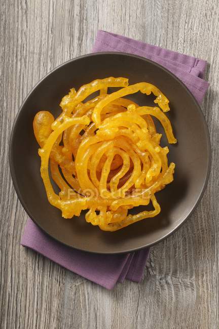 Closeup top view of sugar spirals on black plate — Stock Photo