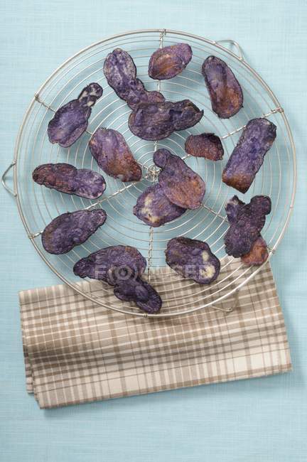 Croustilles de pommes de terre violettes sur le rack — Photo de stock