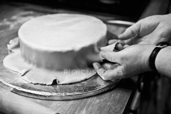 Wedding cake being covered with fondant icing — Stock Photo
