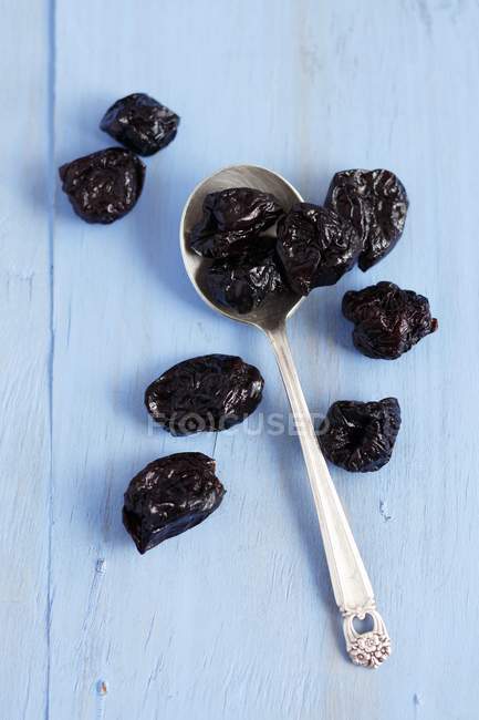 Dried plums with spoon — Stock Photo
