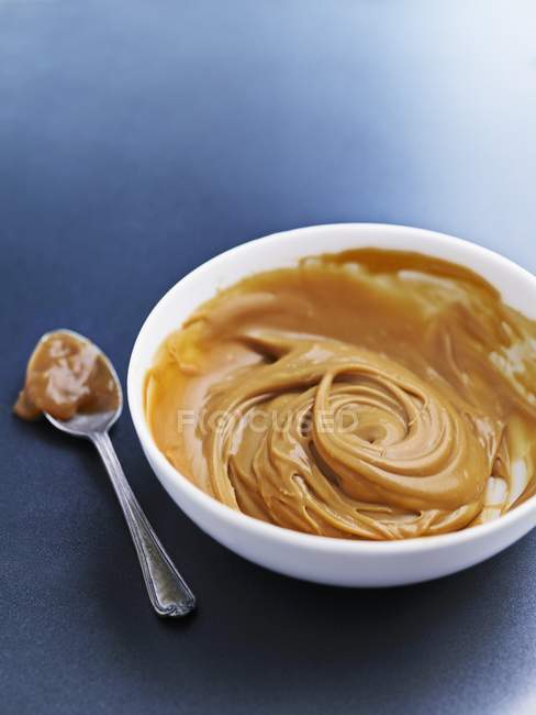 Vue rapprochée de la sauce caramel dans un bol et une cuillère — Photo de stock