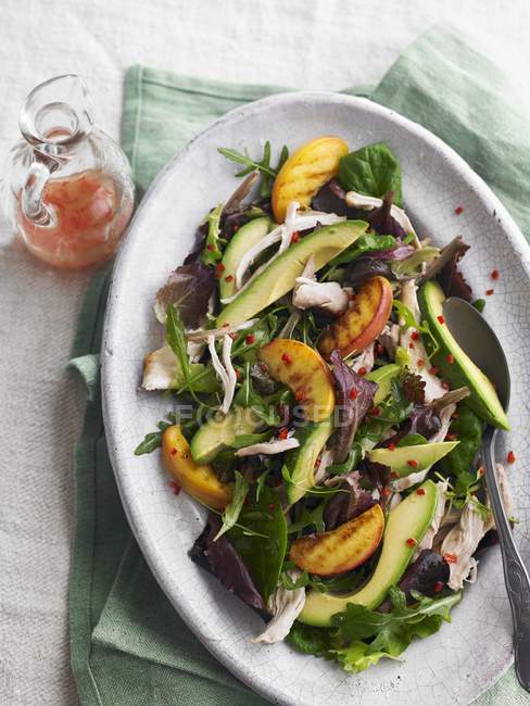 Chicken salad with avocado and grilled peaches — Stock Photo