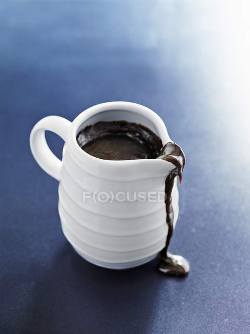 Chocolate sauce in white jug — Stock Photo