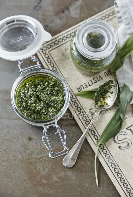 Wild garlic Pesto in a jar and on a spoon — Stock Photo