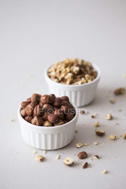 Hazelnuts and walnuts in bowls — Stock Photo