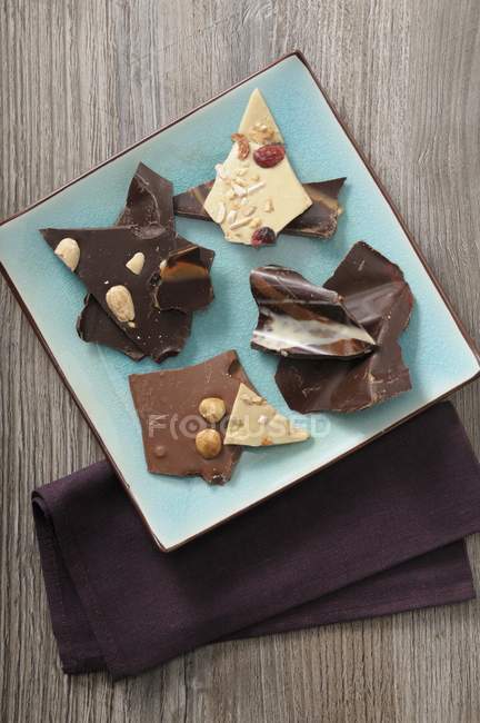 Différents morceaux de chocolat sur assiette — Photo de stock