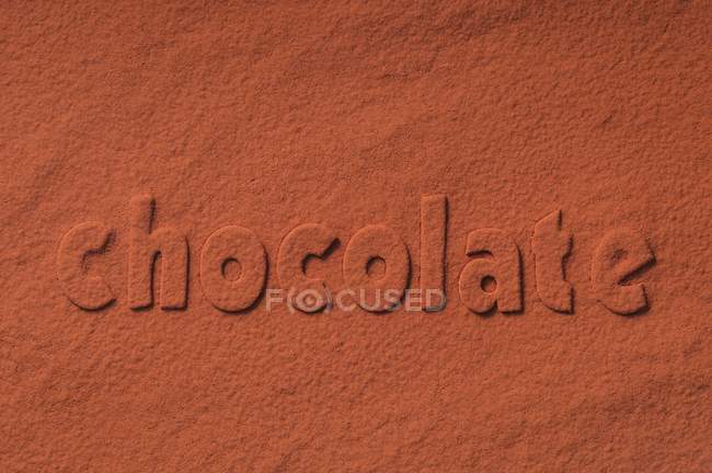 The word 'chocolate' in cocoa powder — Stock Photo