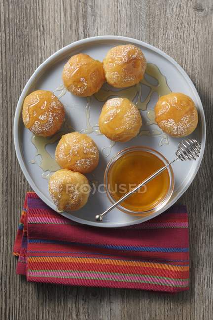 Doughnuts with honey on tray — Stock Photo