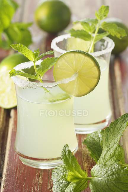 Mojito avec tranches de citron vert et menthe dans des verres — Photo de stock